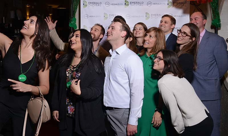 The Emerald Digital and HeraldPR team in front of a branded step-and-repeat
